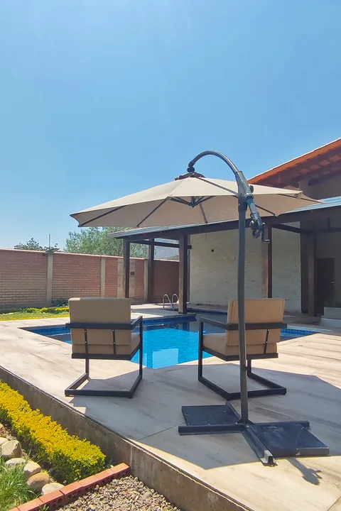Sillones y sombrilla junto al borde de la piscina